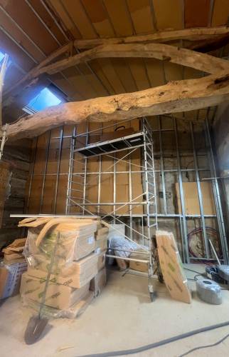 Mise en valeur de la charpente ancienne lors de la transformation intérieure de la grange.