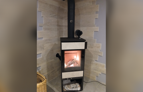 Poêle à bois allumé avec travertin