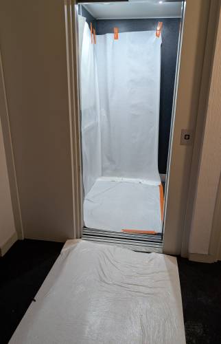 Protection des sols et finitions en cours dans le couloir