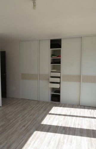 Vue de la porte d'entrée et du placard intégré ouvert, démonstration de l'optimisation d'espace dans un salon.