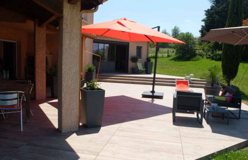 Réalisation d'une terrasse et d'une plage de piscine en dalles gres cérame posées sur plots, maison à Dommartin