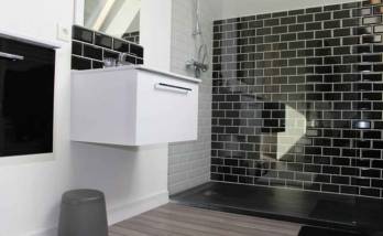 douche avec carrelage noir et un parquet en bois