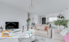 Un salon ouvert sur la cuisine, entièrement rénové avec des murs blancs éclatants et des finitions modernes. La décoration sobre et élégante met en valeur l'espace lumineux.