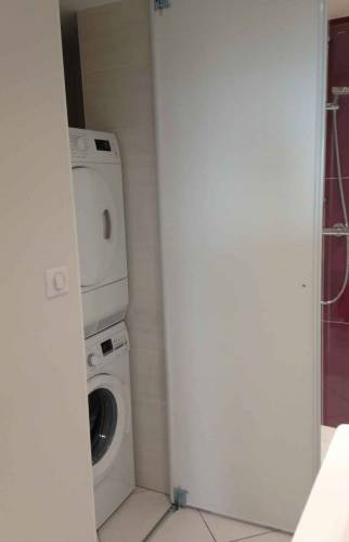 Espace buanderie caché dans un placard de la salle de bain