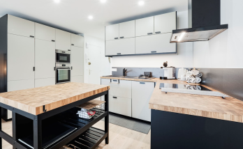 Cuisine contemporaine équipée avec nombreux rangements, îlot central et électroménager encastré
