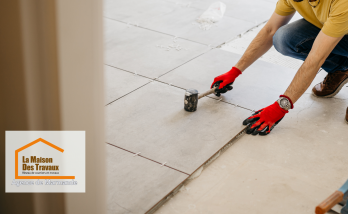 Sur cette image, on peut voir un artisan professionnel, équipé des outils appropriés, procéder à la pose des carreaux. 