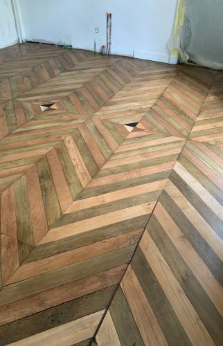 Différentes essences de bois créent ce joli parquet massif bicolore