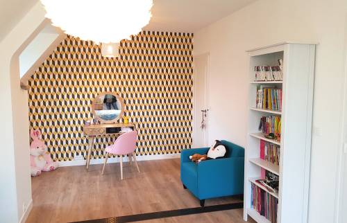 coiffeuse en bois clair avec fauteil rose poudre et papier peint bibiothéque blanche et fauteil bleu