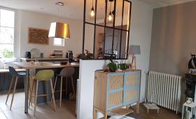 Vue cuisine depuis le salon avec une belle verrière d'atelier industrielle