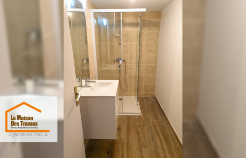 Une salle d’eau élégante et fonctionnelle a été aménagée avec une douche à l’italienne et des finitions modernes pour plus de confort.