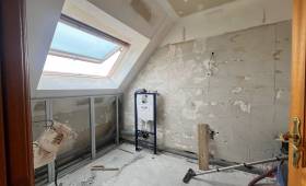 Début des travaux de rénovation d'une salle de bain avec murs déposés, bâti-support WC et préparation de plomberie.