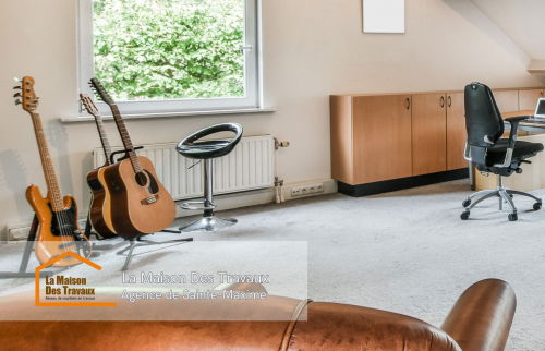 Vue sur l’espace de travail et de détente dans les combles, offrant un environnement chaleureux et fonctionnel.