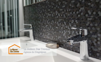 Un meuble sous-vasque suspendu moderne et pratique, avec un mur en carrelage mosaïque pour une touche élégante.