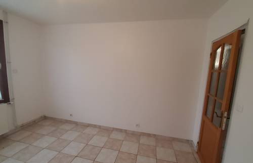 Ancienne chambre avec carrelage et porte vitrée avant les travaux d'agrandissement.