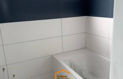Habillage mural en faïence blanche  – rénovation salle de bain avec carreaux de ciment au sol à Saint-Brieuc