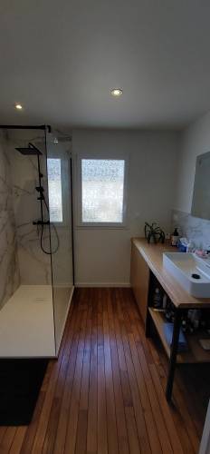 Vue d'ensemble de la salle de bain, sol en parquet pont de bateau, faïence effet marbre dans la douche