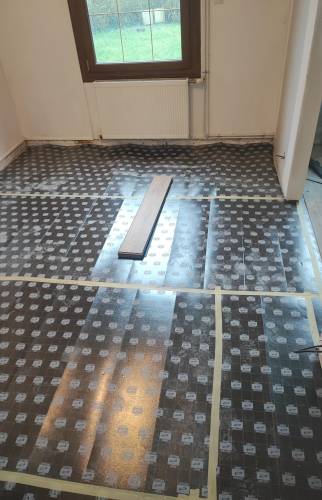 Préparation du sol avec pose d'une sous-couche isolante sur l'ancien carrelage.