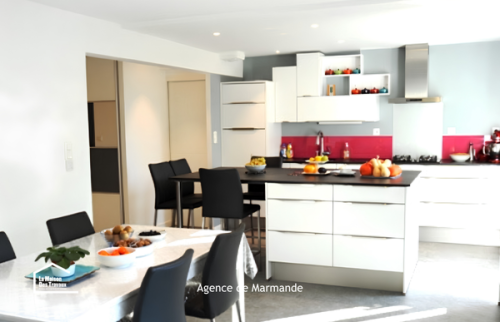 Vue d’une cuisine ouverte rénovée près de Tonneins avec grand plan de travail, espace repas lumineux et circulation optimisée vers le séjour.