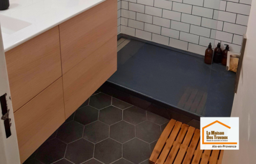Vue d’ensemble d’une salle de bain moderne rénovée près du Tholonet avec douche à l’italienne, meuble vasque suspendu et carrelage métro blanc.