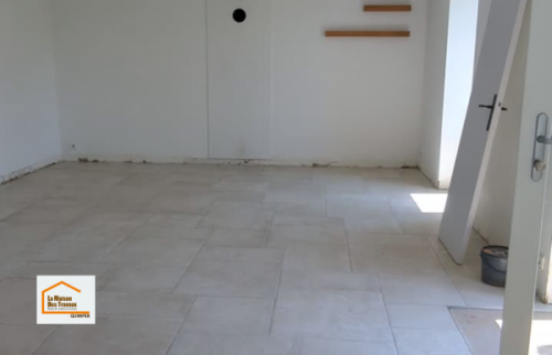 Vue d’ensemble de la nouvelle pièce de vie après la pose du carrelage, avant l’installation de la cuisine. Une rénovation coordonnée par La Maison Des Travaux Quimper dans le Finistère Sud.