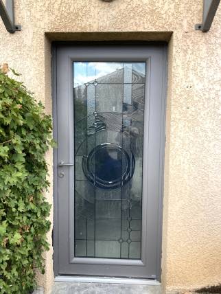 Rénovation d'une porte d'entrée, dans un style Art Déco, maison située à Ecully (69130) : porte en aluminium, double vitrage, coloris gris texturé