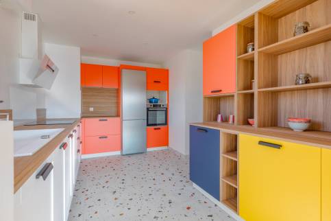 Cuisine multicolore dans un appartement de Lyon (69009) avec ouverture sur le séjour