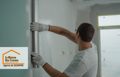Finition des murs à Treffiagat – Un artisan applique les dernières touches sur des cloisons isolées, garantissant une finition impeccable.