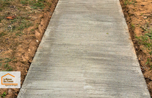 Finition striée du béton pour un effet antidérapant, garantissant sécurité et durabilité du chemin extérieur.