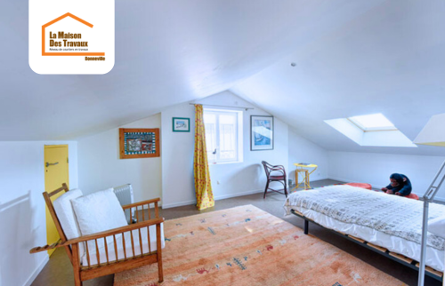 Chambre sous combles aménagée à Thyez 74300 avec mobilier bois, murs blancs, lumière naturelle et Velux – rénovation intérieure en Haute-Savoie.