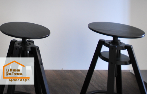 Zoom sur l’ambiance chaleureuse d’une pièce rénovée à Agen : parquet foncé et mobilier noir pour une atmosphère design et contemporaine.