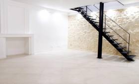 Pièce de vie, mur en pierre et escalier métallique