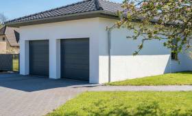 garage blanc avec un grand jardin vert