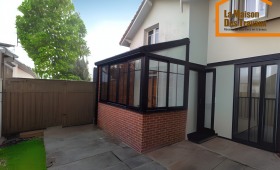 APRES Véranda en aluminium noir style verrière avec muret en brique