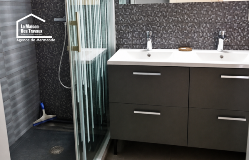 Salle de bain rénovée à Casteljaloux, douche confortable et sol en carrelage imitation bois chaleureux.