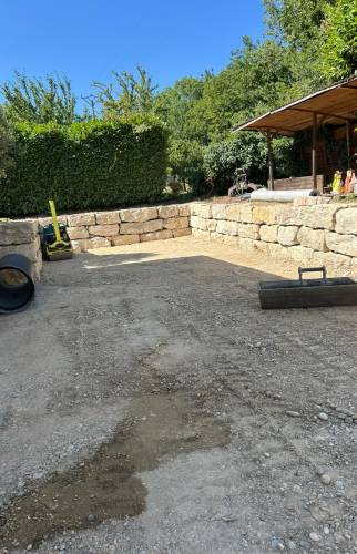 Cour prête à recevoir son revêtement final après terrassement, nivellement et mise en forme complète du terrain.