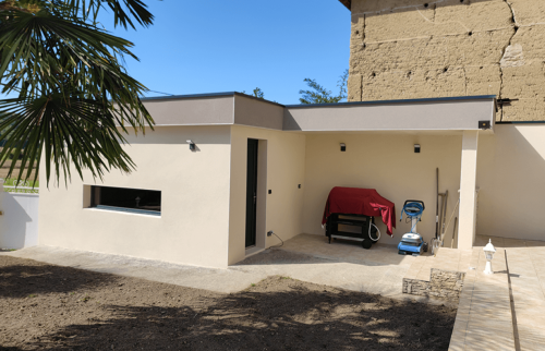 Garage et cuisine d’été réunis sous une toiture plate contemporaine à Saint-Cassien.
