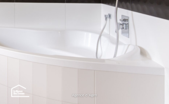 Salle de bain rénovée à Agen avec baignoire d’angle, WC suspendu et carrelage noir et blanc contemporain.