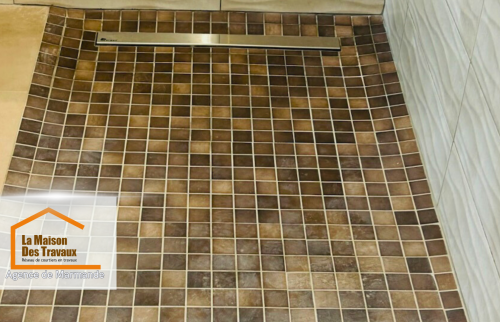 Douche à l’italienne moderne – Zoom sur le receveur à carreaux antidérapants et la rigole de drainage, garantissant une évacuation efficace de l’eau et une sécurité optimale.