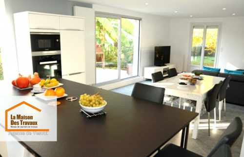 Cuisine moderne rénovée à Lure – Espace lumineux avec îlot central, meubles blancs et touches de rouge. Design élégant et fonctionnel.