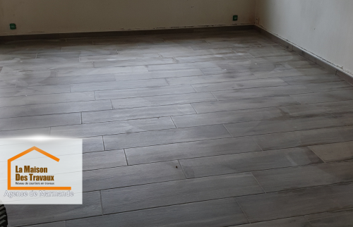 Le résultat après rénovation : un sol en carrelage imitation bois, chaleureux et intemporel, accompagné d’une verrière noire qui apporte une touche industrielle et élégante. 