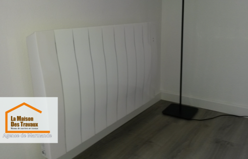 Un radiateur moderne soigneusement installé, s’intégrant parfaitement dans un intérieur rénové avec des finitions épurées.