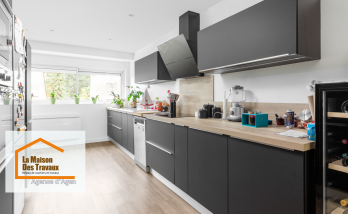 Rénovation de cuisine à Layrac : Transformation moderne avec meubles noirs et plan de travail en bois. Une cuisine élégante et fonctionnelle.