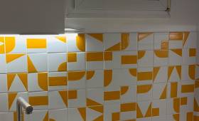 Rénovation cuisine Paris, crédence en carreaux graphiques orange et blanc, vue d'ensemble
