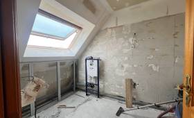 Début des travaux de rénovation d'une salle de bain avec murs déposés, bâti-support WC et préparation de plomberie.