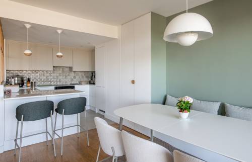 Banquette confortable et mur vert dans une cuisine rénovée