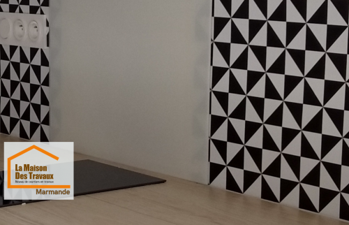 Zoom sur la crédence graphique noir et blanc de cette cuisine rénovée à Marmande. Un design moderne et durable idéal pour un appartement destiné à la location.