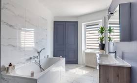 Rénovation complète d'une salle de bains, carrelage imitation marbre blanc et peintures bleu gris