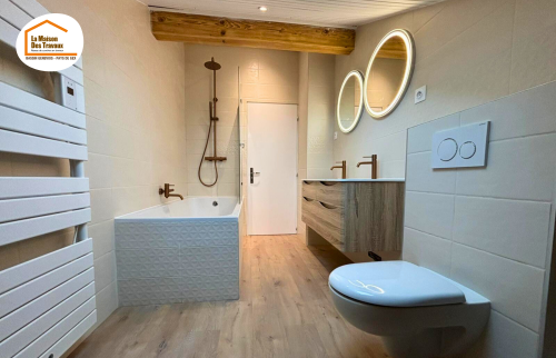 faïence salle de bains texturée, parquet salle de bain, baignoire moderne salle de bain, rénovation intérieure Nantua, salle de bain sous pente