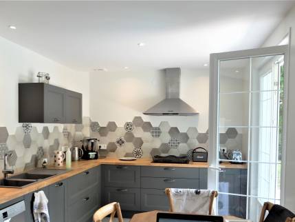 Cuisine rénovée et agrandie dans une villa de l’ouest lyonnais avec crédence carrelée et verrière d’atelier