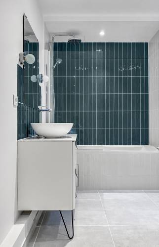 Carreaux muraux bleus brillants dans une salle de bain moderne à Paris 16